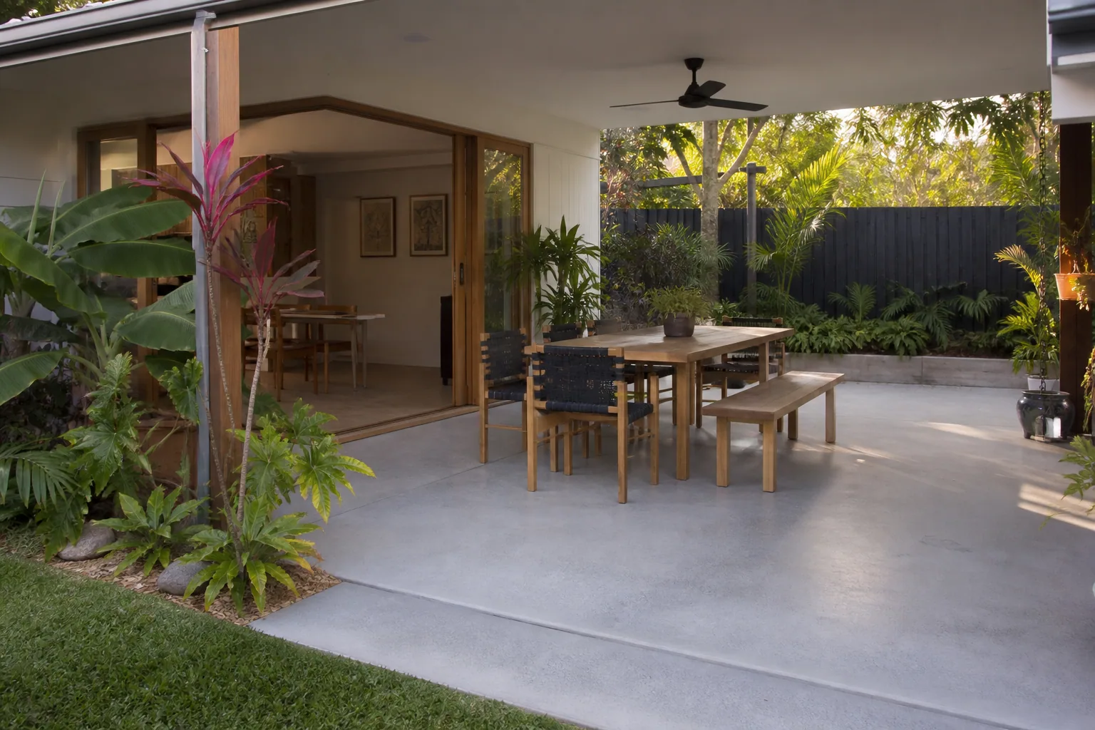 Honed concrete patio opening to a subtropical Gold Coast garden